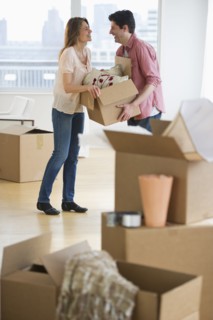 USA, New Jersey, Jersey City, Couple carrying box in new home.