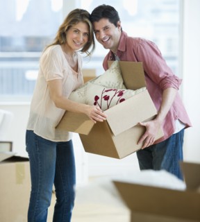 USA, New Jersey, Jersey City, Portrait of couple carrying box in new home.