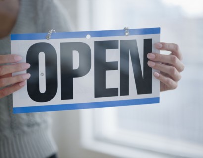 USA, New Jersey, Jersey City, Close-up view of woman holding open sign. Photo : Jamie Grill