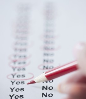 USA, New Jersey, Jersey City, Close-up view of woman's hand filling in form. Photo : Jamie Grill