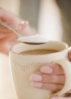USA, New Jersey, Jersey City, Close-up view of human hand putting sugar into cup of coffee. Photo :