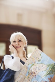 USA, Seattle, Young woman talking via phone and holding map. Photo : Take A Pix Media