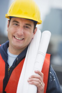 USA, New Jersey, Jersey City, Portrait of construction worker holding blueprints on construction site.