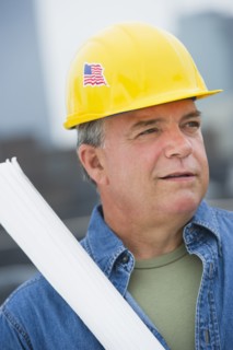 USA, New Jersey, Jersey City, Construction worker holding blueprints on construction site.