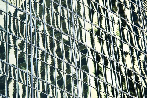 USA, New York, New York City, Reflections in windows of office block.