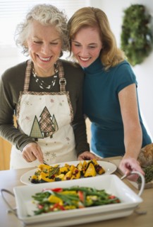 USA, New Jersey, Jersey City, Mother and daughter preparing food in kitchen.