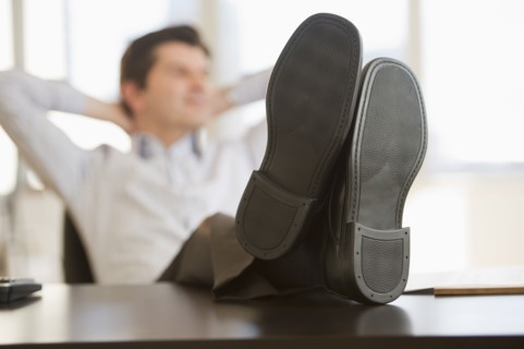 USA, New Jersey, Jersey City, Businessman with feet up on desk.