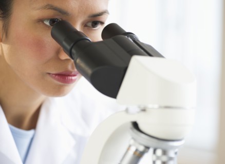 USA, New Jersey, Jersey City, Female scientist using microscope.