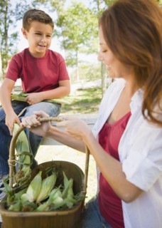 USA, New York, Flanders, Mother and son (8-9) with basket of corns. Photo : Jamie Grill Photography