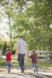 USA, New York, Flanders, Father with two sons (4-5, 8-9) walking in farm. Photo : Jamie Grill