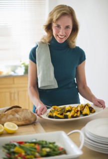 USA, New Jersey, Jersey City, Portrait of woman preparing food in kitchen.
