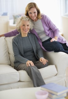 USA, New Jersey, Jersey City, Portrait of mother and daughter smiling on sofa.