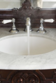 Bathroom sink with hot water running.