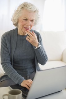 USA, New Jersey, Jersey City, Senior woman using laptop in living room.