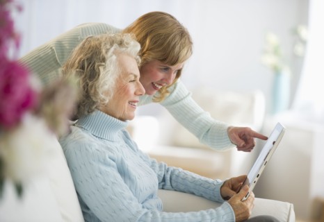 USA, New Jersey, Jersey City, Senior mother and daughter using digital tablet on sofa.