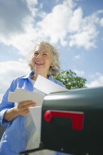 USA, New Jersey, Jersey City, Senior woman checking mail at mailbox.