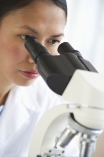USA, New Jersey, Jersey City, Female scientist using microscope.