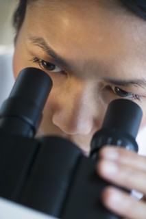USA, New Jersey, Jersey City, Female scientist using microscope.