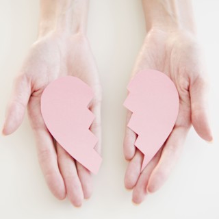USA, New Jersey, Jersey City, Woman's hand holding two halves of heart. Photo : Jamie Grill