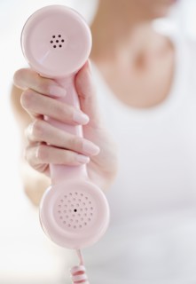 USA, New Jersey, Jersey City, Woman's hand holding pink telephone receiver. Photo : Jamie Grill