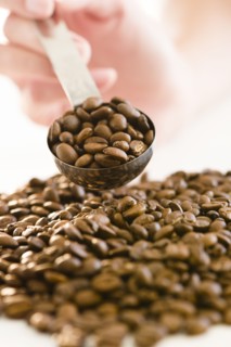 USA, New Jersey, Jersey City, Close-up view woman's hand holding spoon filled with coffee beans.