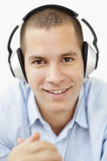 South Africa, Young man wearing earphones and looking at camera, studio shot. Photo : momentimages