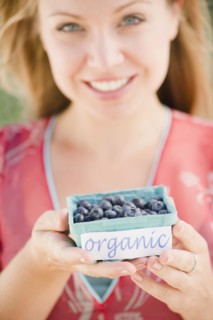 USA, New Jersey, Jersey City, Young attractive woman offering box of blueberries. Photo : Jamie