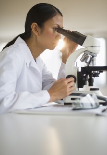 USA, New Jersey, Jersey City, Female scientist using microscope.