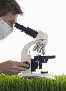 Man looking through microscope in studio.