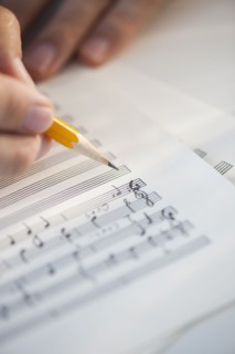 Man writing notes on sheet music.