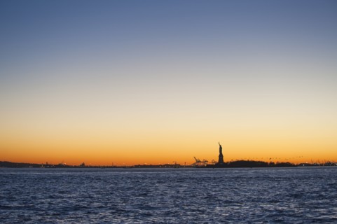 USA, New York City, Staten Island, Harbor and silhouette of Statue of Liberty in background.