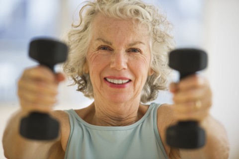 USA, New Jersey, Jersey City, Portrait of senior woman using hand weights at gym.