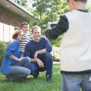 USA, New York, Flanders, Boy (4-5) taking photograph of mother, father and brother (8-9). Photo :