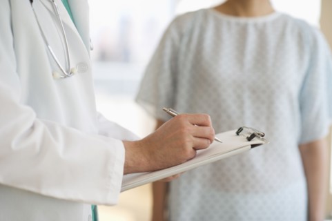 USA, New Jersey, Jersey City, Male doctor writing medical report with patient.