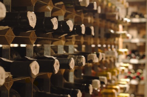 Old wine bottles on cellar shelves.