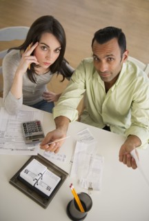 Couple doing taxes and looking at camera.
