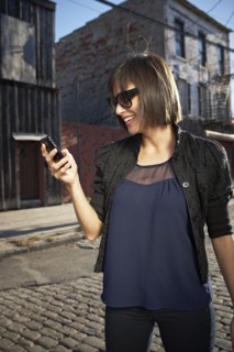 USA, New York City, Brooklyn, woman in street using phone. Photo : Shawn O'Connor