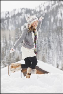 USA, Utah, Salt Lake City, young woman walking through snow in resort. Photo : Mike Kemp