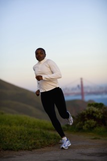 USA, California, San Francisco, Woman jogging, Golden Gate Bridge in background. Photo : Noah