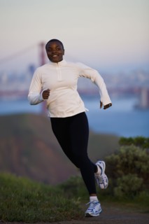USA, California, San Francisco, Woman jogging, Golden Gate Bridge in background. Photo : Noah
