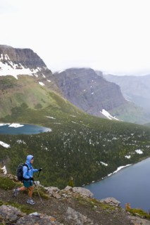 USA, Montana, Glacier National Park, Mid adult woman hiking with backpack during rain. Photo : Noah
