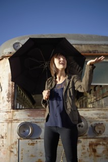USA, New York City, Brooklyn, woman with umbrella checking for rain. Photo : Shawn O'Connor