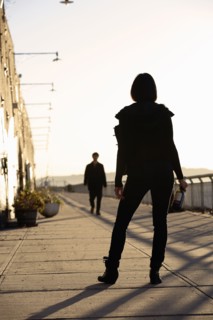 USA, New York City, Brooklyn, woman with bottle standing in street. Photo : Shawn O'Connor