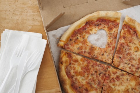 Pizza with missing heart shaped piece.