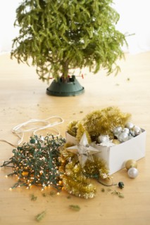 Christmas tree and christmas ornaments on floor.