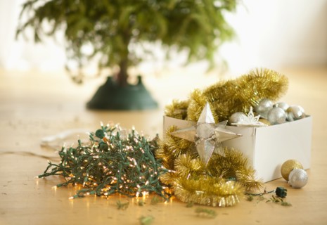 Christmas tree and christmas ornaments on floor.
