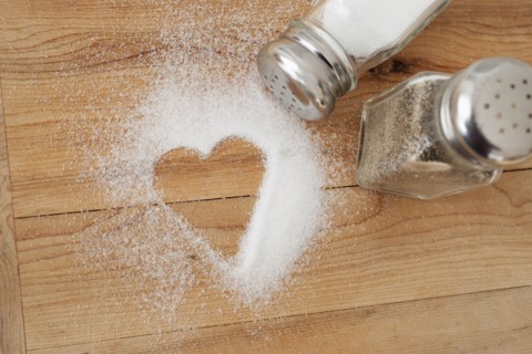 Heart shaped spilt salt on table.