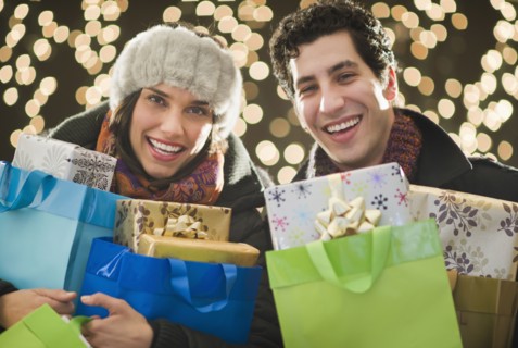 Happy couple holding Christmas presents.