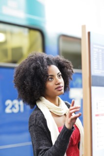 USA, Washington State, Seattle, young woman looking at arrival departure board. Photo : Take A Pix