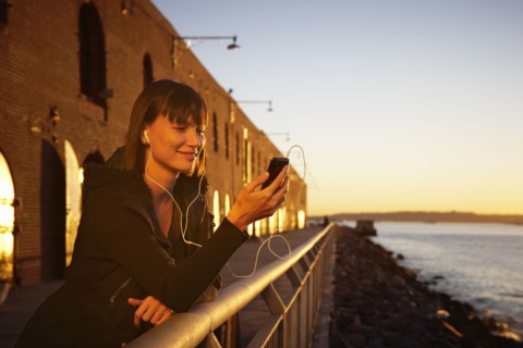 USA, New York City, Brooklyn, woman listening to mp3 player. Photo : Shawn O'Connor